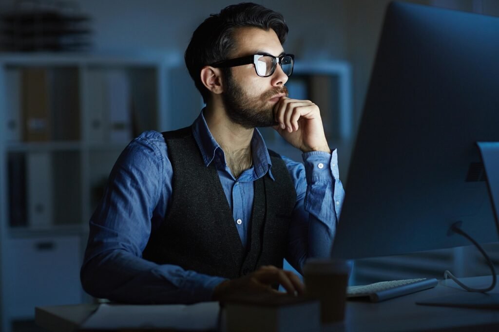 Business man sitting & thinking view in front of LED Computer screen