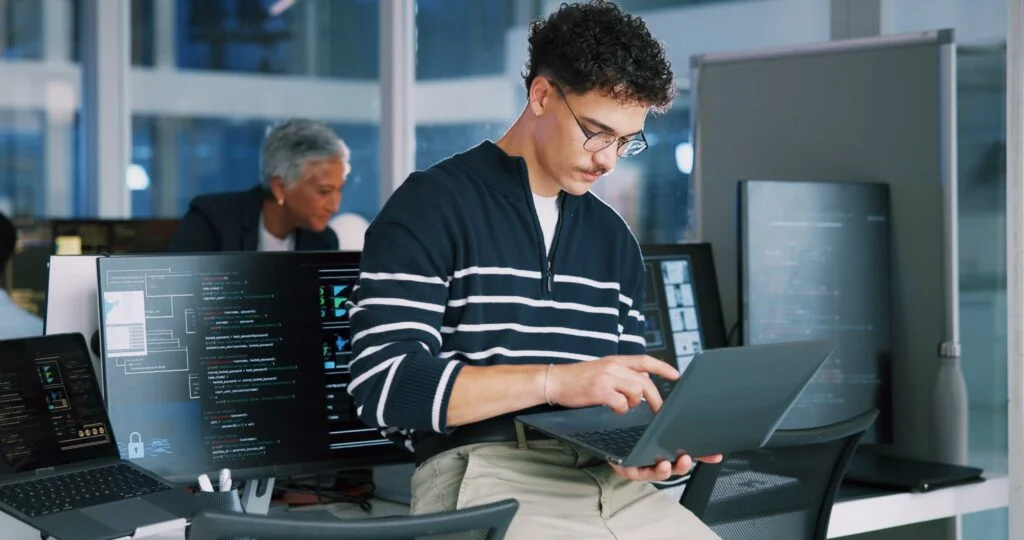 The Top 10 Technologies Powering The Modern Workplace Man, programmer and office with laptop for coding, software development or app design. Male person, coder or developer with computer or technology for cybersecurity, web or IT services at workplace